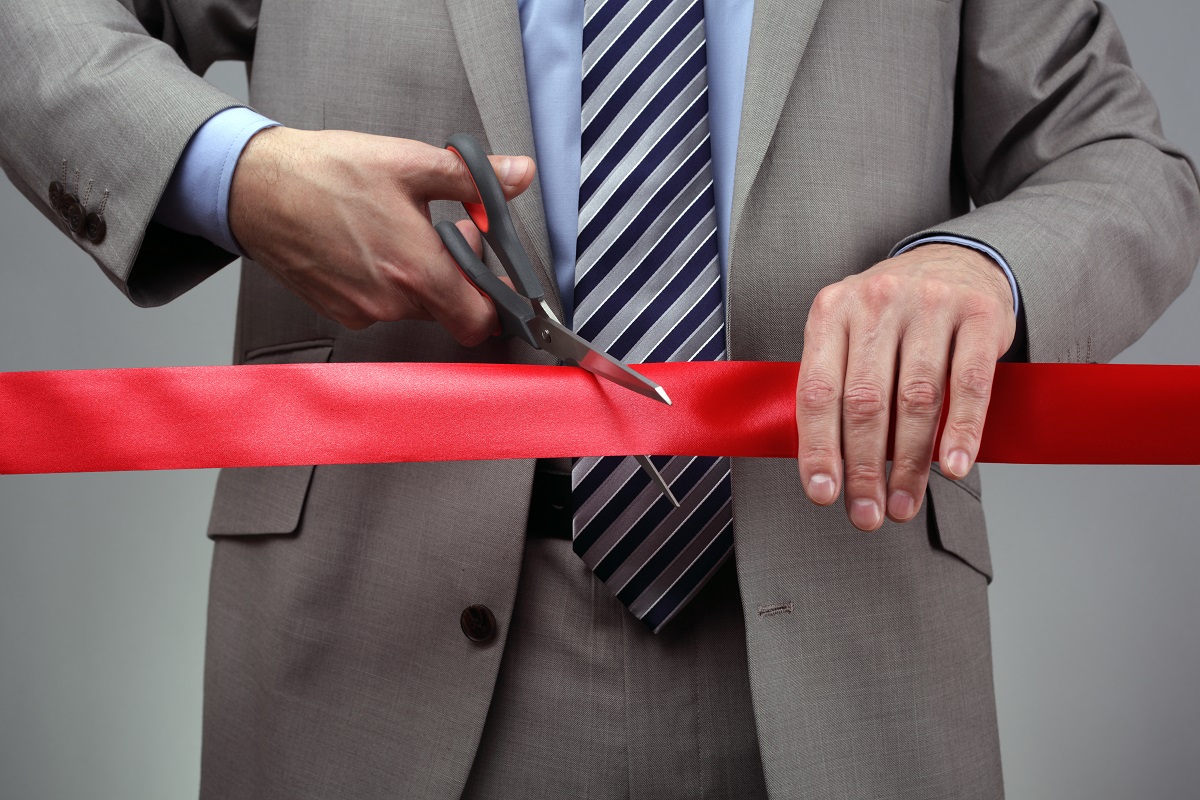 Man cutting a ribbon for his new venture