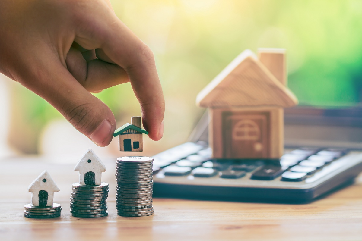 Tiny house model on stack of coins mortgage concept