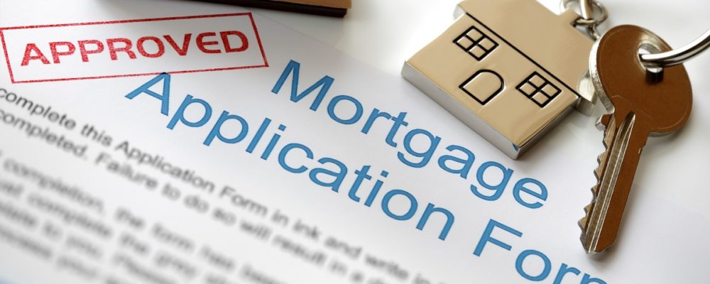 Approved mortgage loan application with stamp and house key