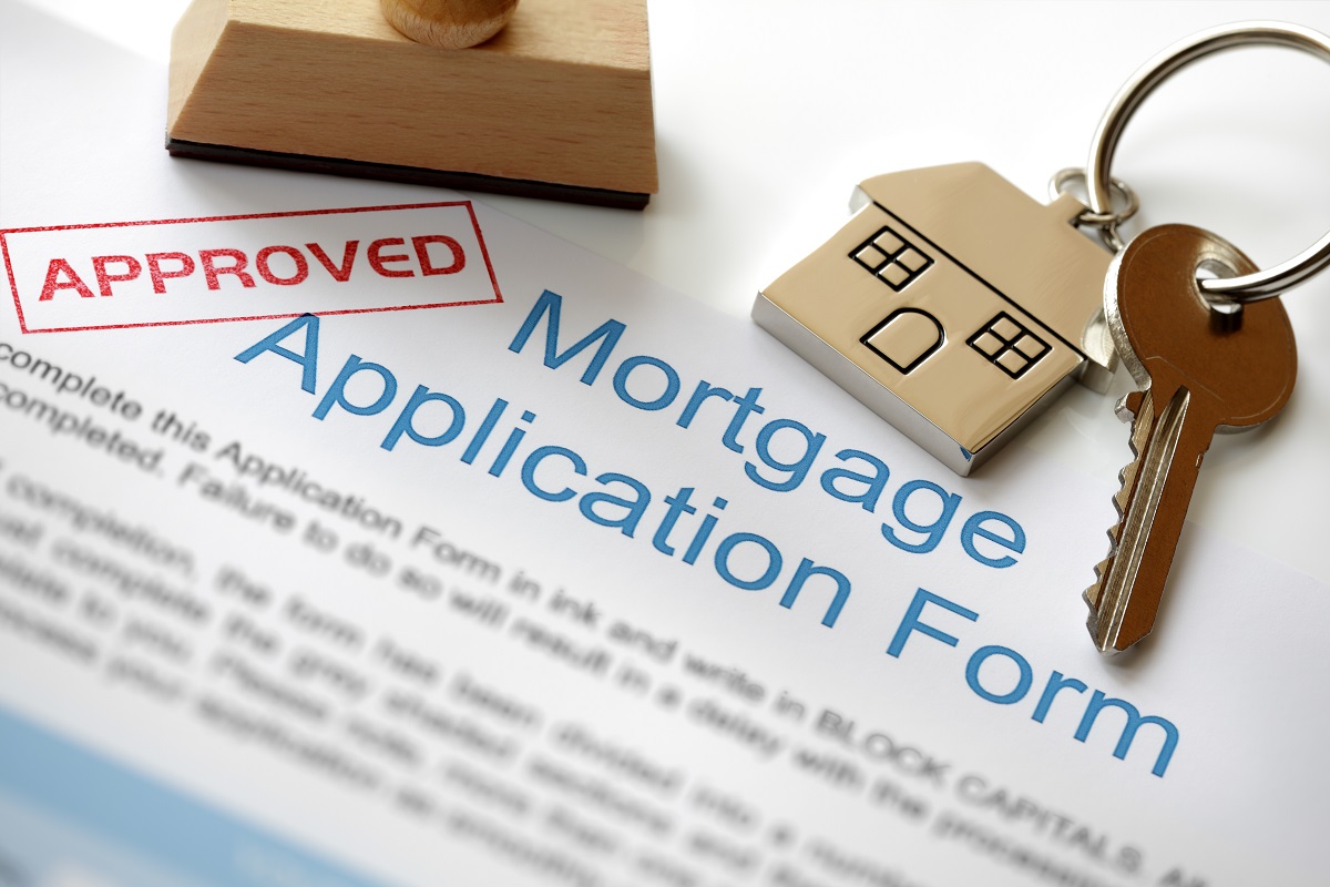 Approved mortgage loan application with stamp and house key