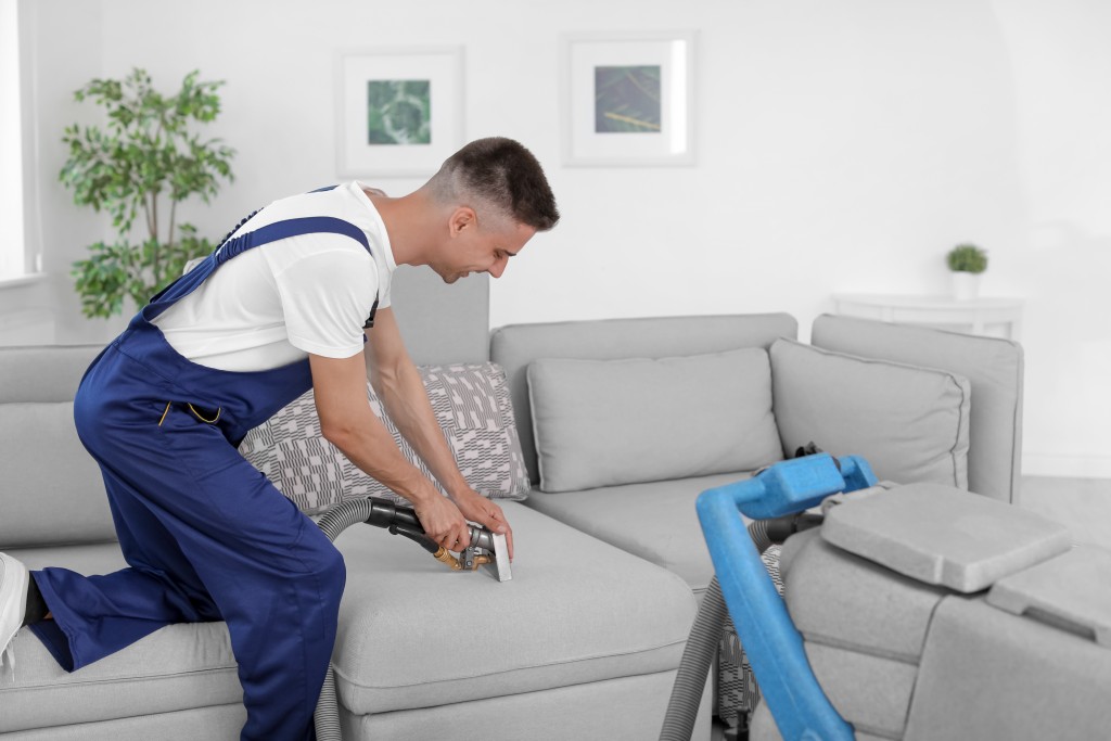 Man cleaning the house using a vacuum