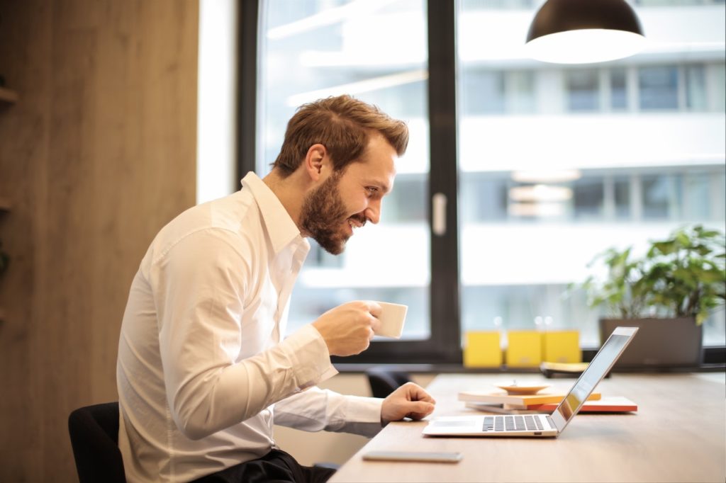 man smiling at his computer