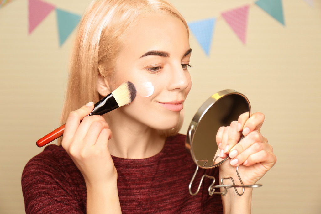 woman putting on makeup