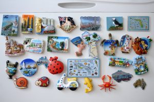 many different travel magnet souvenires on the fridge